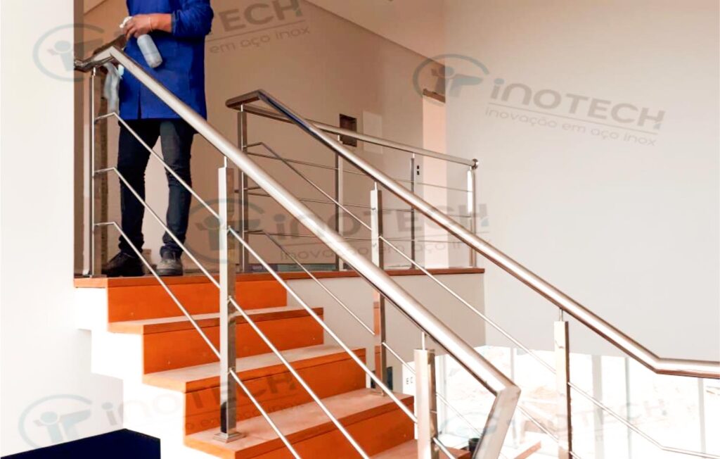 Foto de corrimão de aço inox com guarda-corpo em escada.